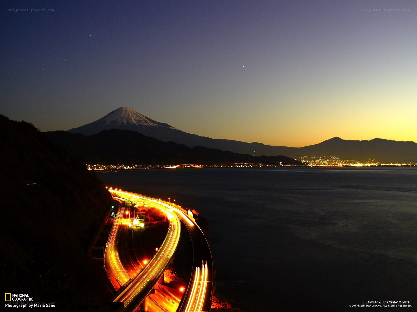 Mount Fuji at dusk with highway lights