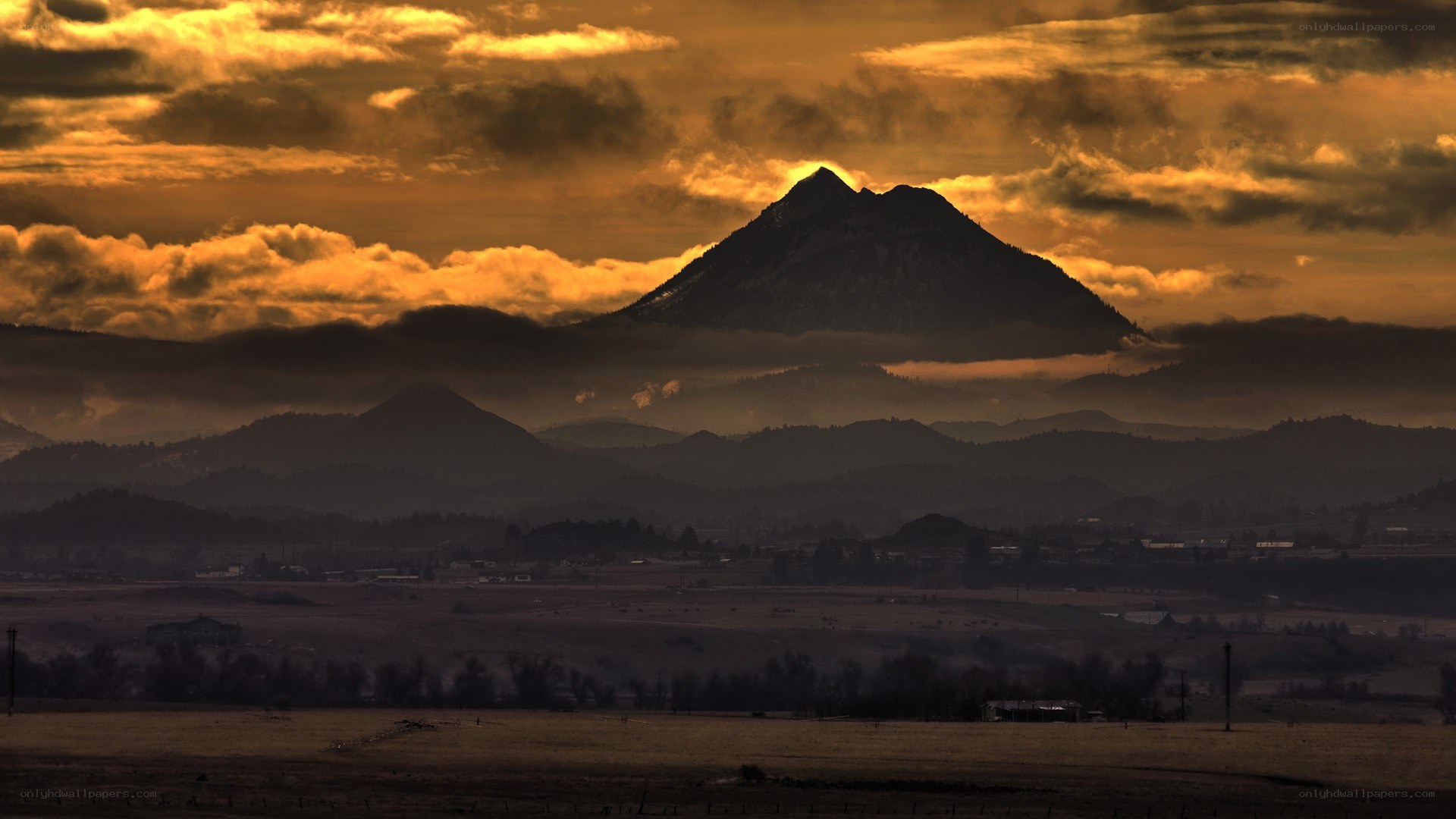 Mountain at sunset with golden clouds