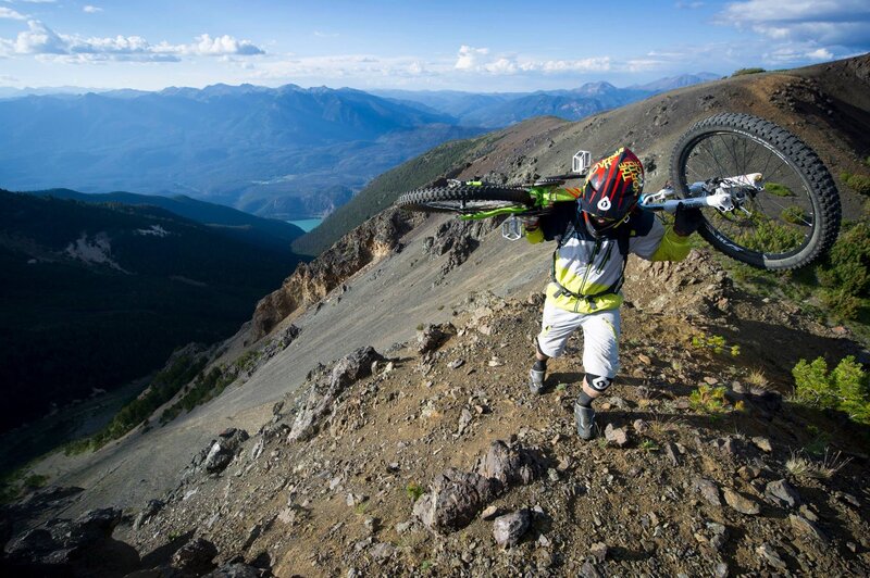 Mountain biker carrying bike on trail