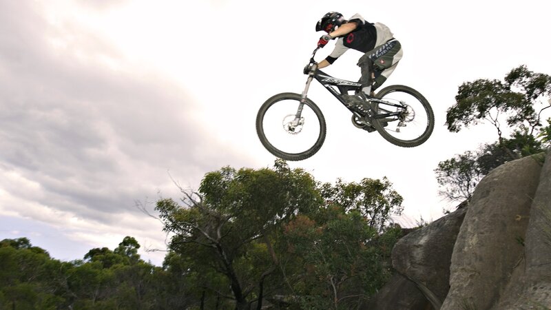 Mountain Biker in Mid-air — Green, Dynamic, Afternoon, Photograph, Bicycle, Trees