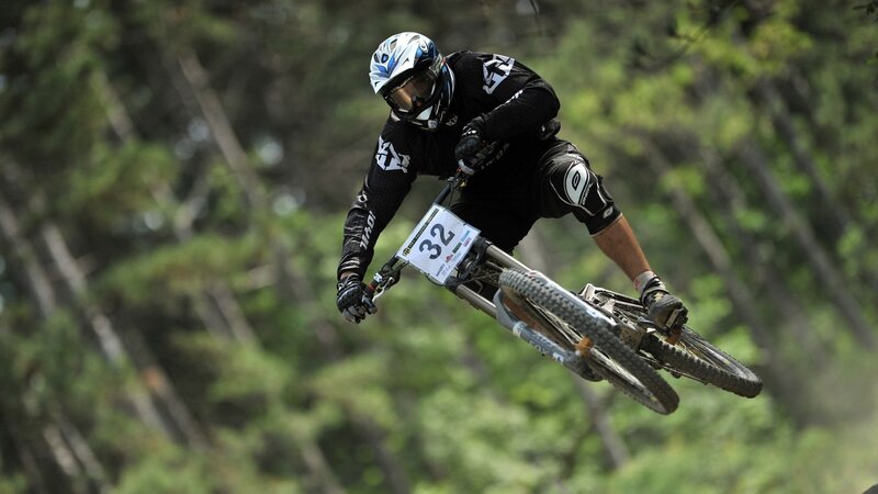 Mountain Biker in Mid-air — Green, Dynamic, Afternoon, Photograph, Helmet
