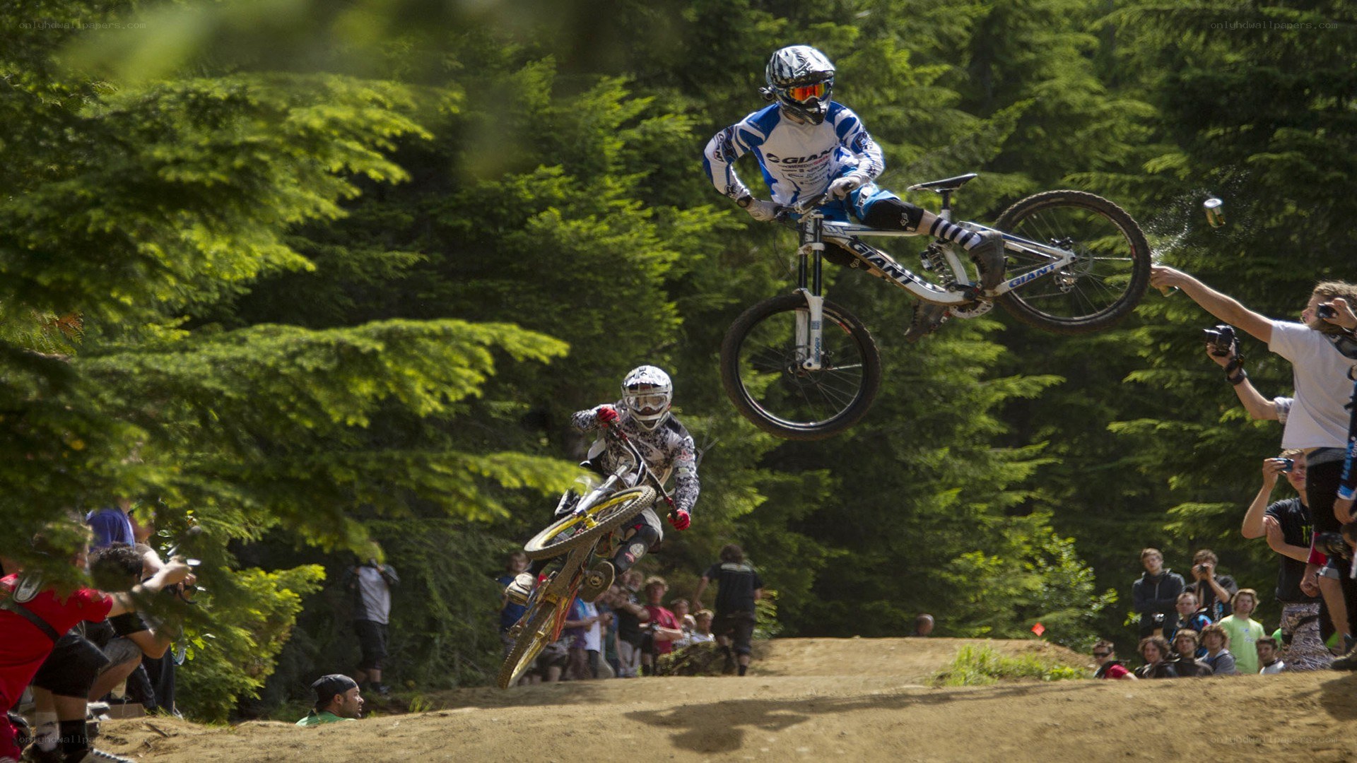 Mountain bikers in mid-air jump