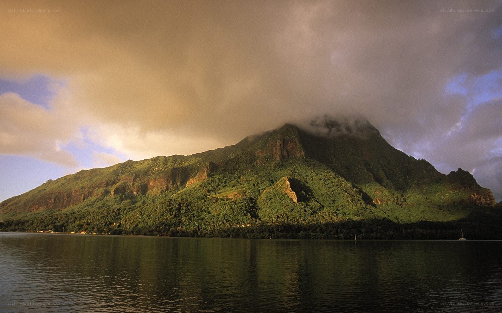 Mountain by the water at sunset