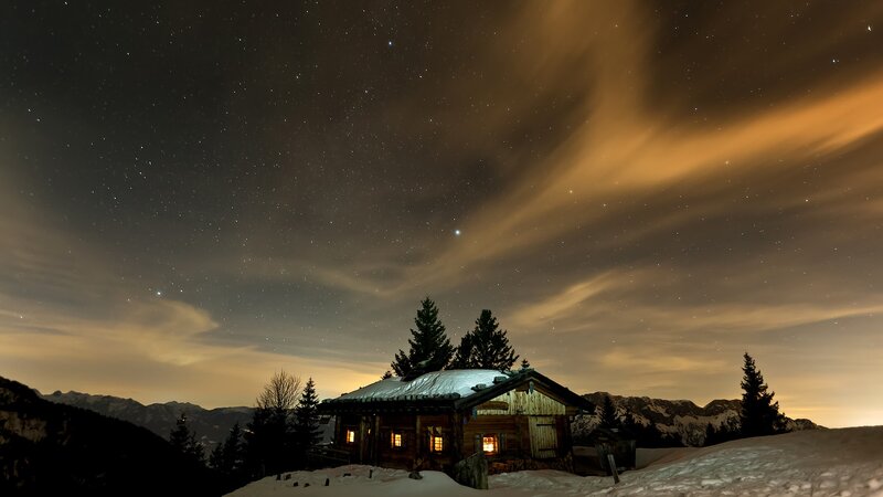 Mountain cabin under starry sky