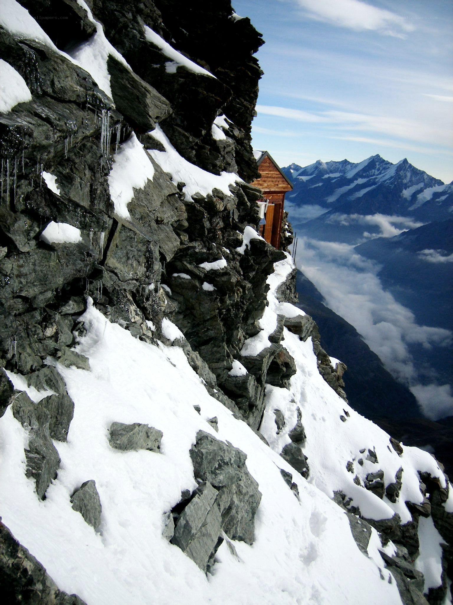 Mountain hut on snowy cliff