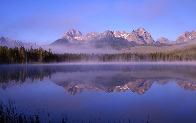 Mountain lake at dawn with fog