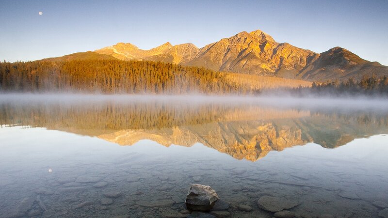Mountain lake at dawn with mist