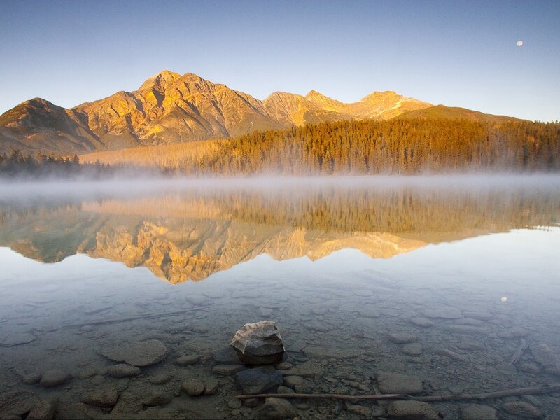 Mountain lake at dawn with moon