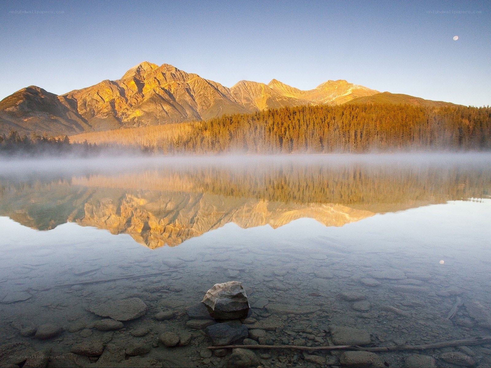 Mountain lake at dawn with moon