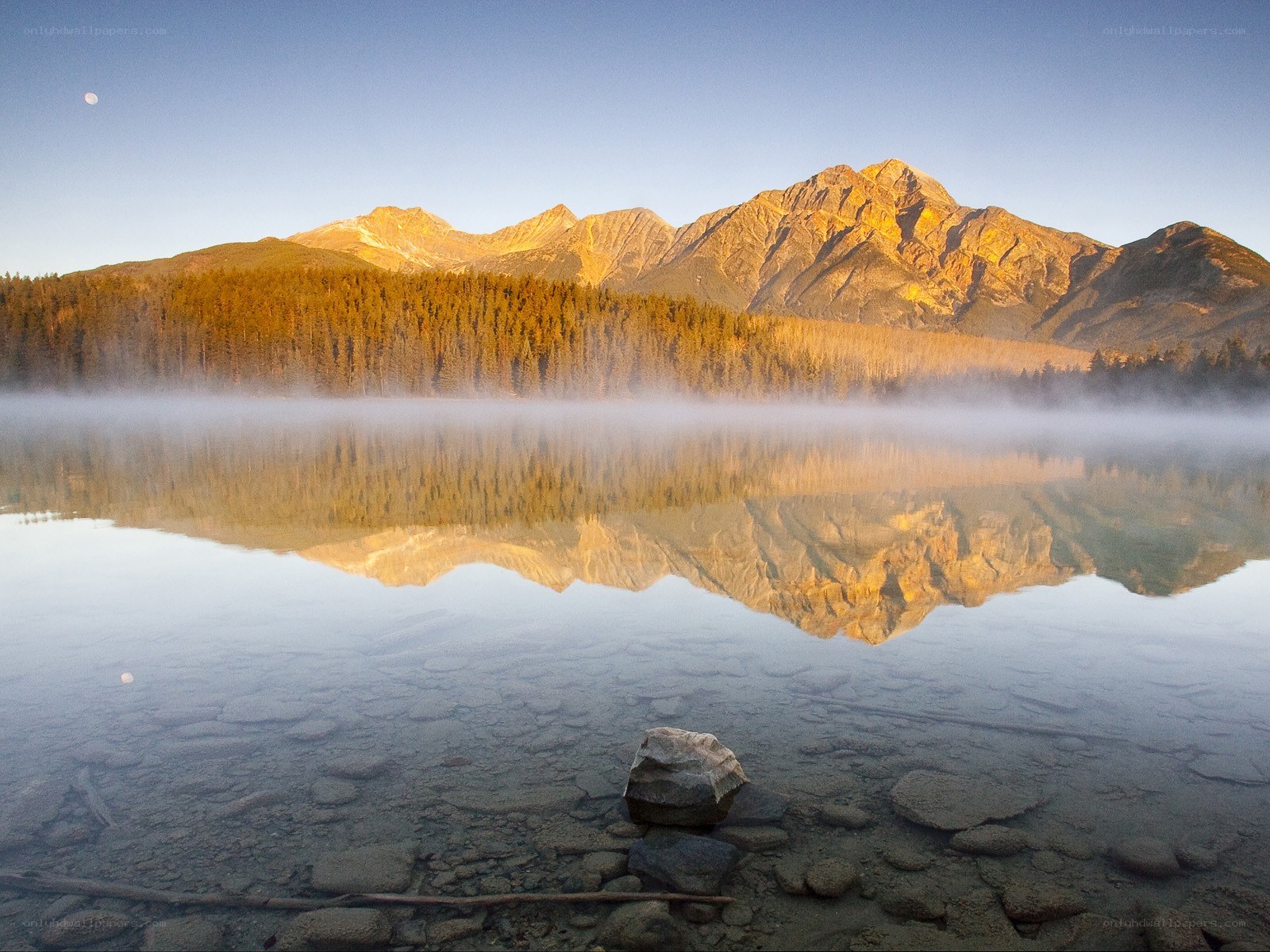 Mountain lake at dawn with moon