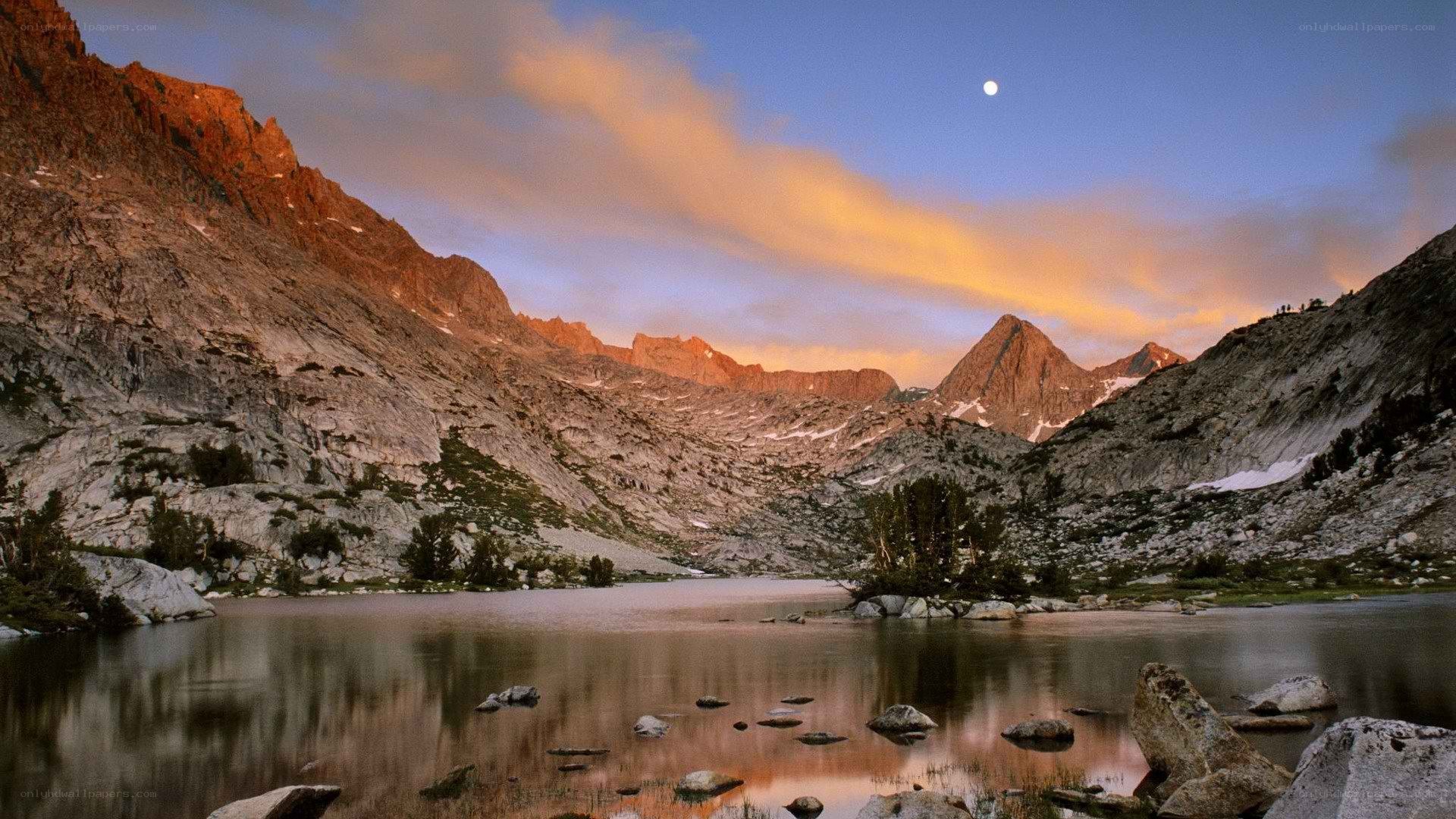 Mountain lake at dusk with moon