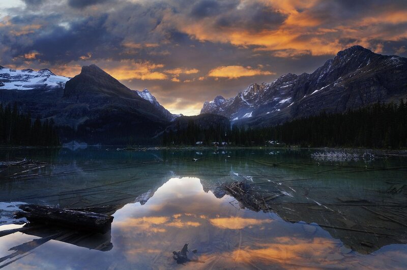 Mountain Lake at Sunset — Orange, Dramatic, Photograph, Mountains, Forest, Clouds, Driftwood