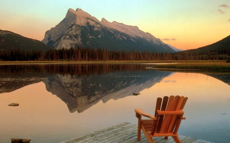 Mountain lake at sunset with Adirondack chair