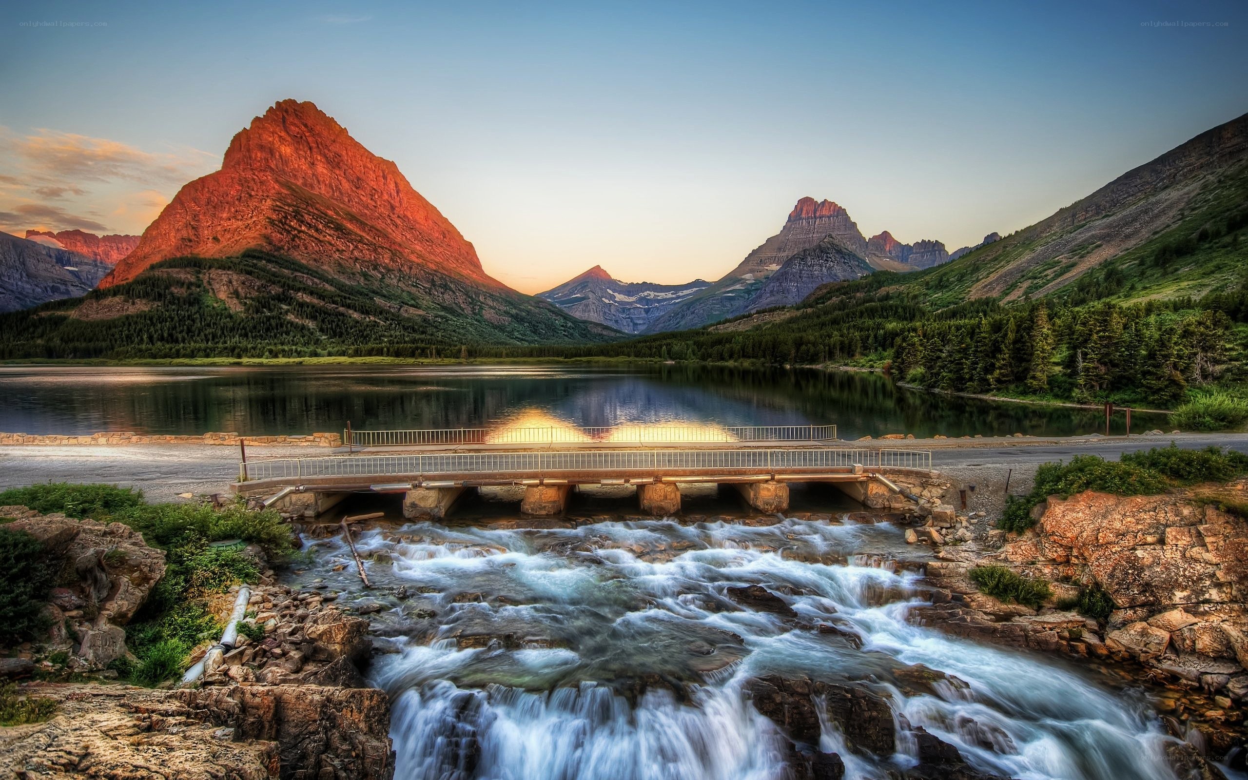 Mountain lake at sunset with bridge