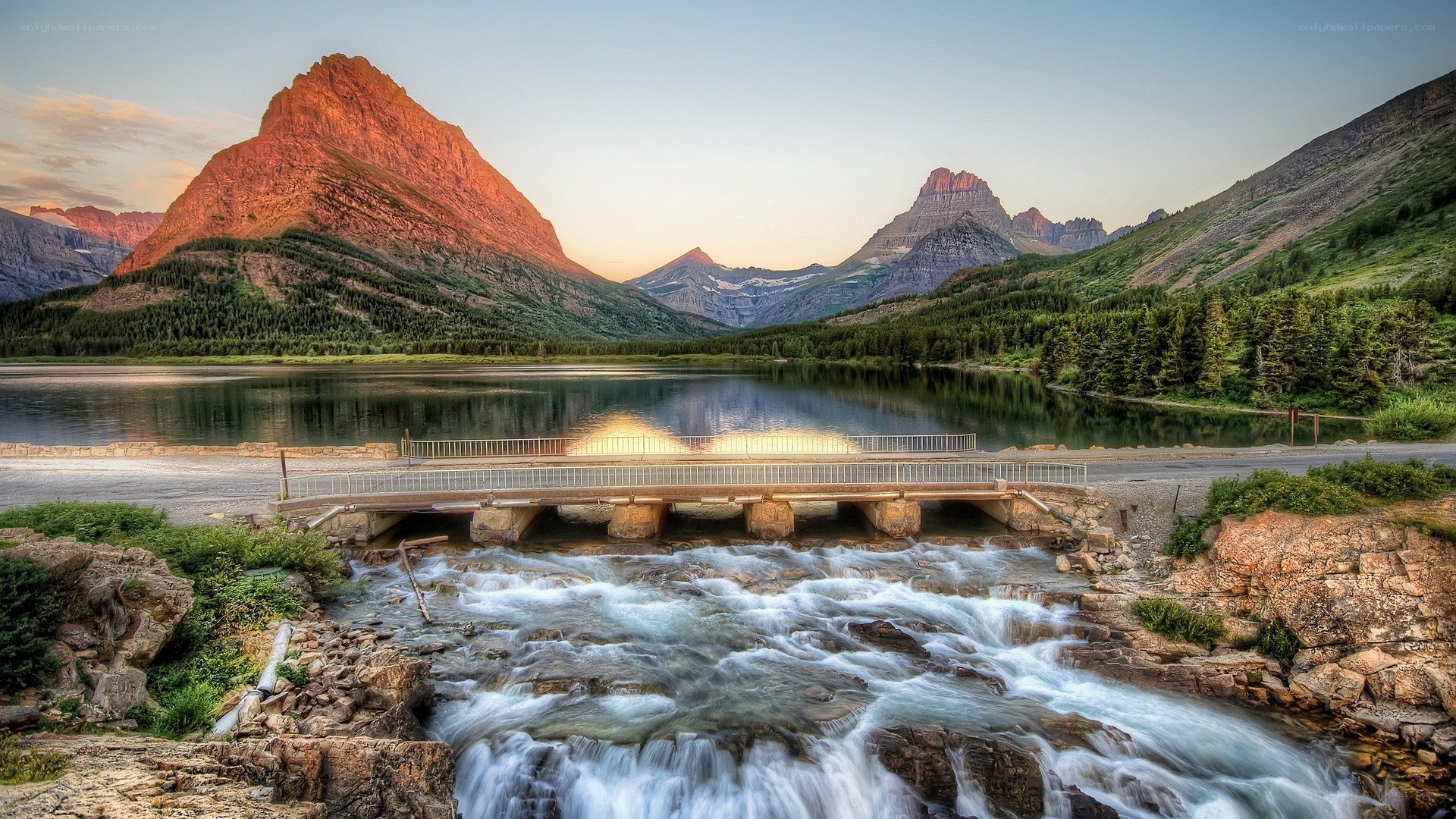 Mountain lake at sunset with waterfall