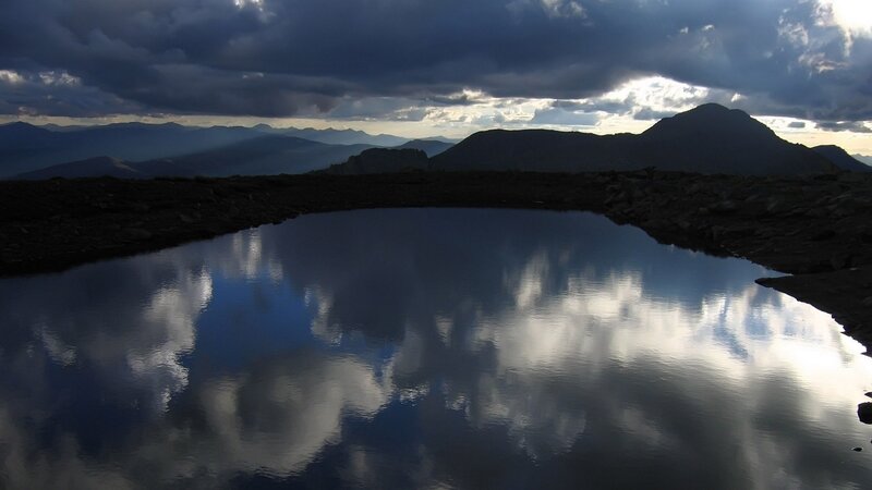 Mountain lake reflecting storm clouds