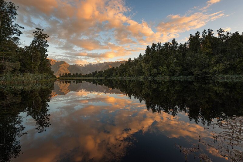 Mountain Lake Reflection — Orange, Serene, Sunset, Photograph, Mountains, Trees, Clouds