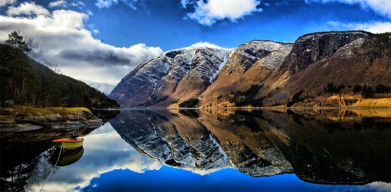 Mountain lake reflection with boat