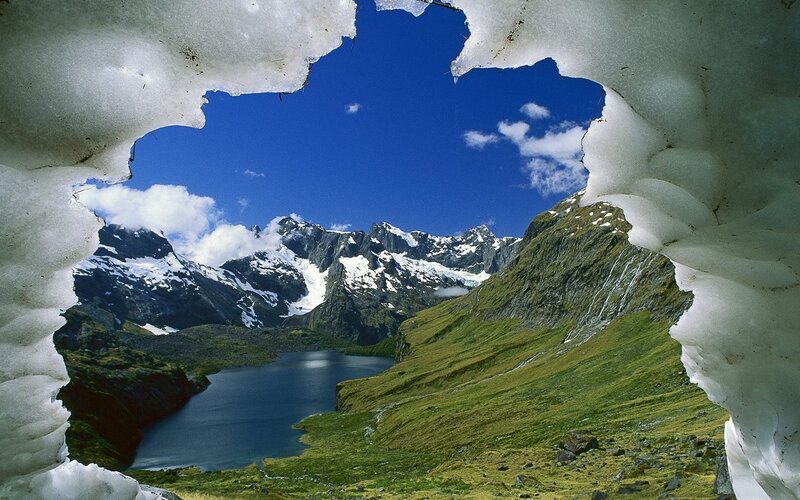 Mountain lake through snow tunnel