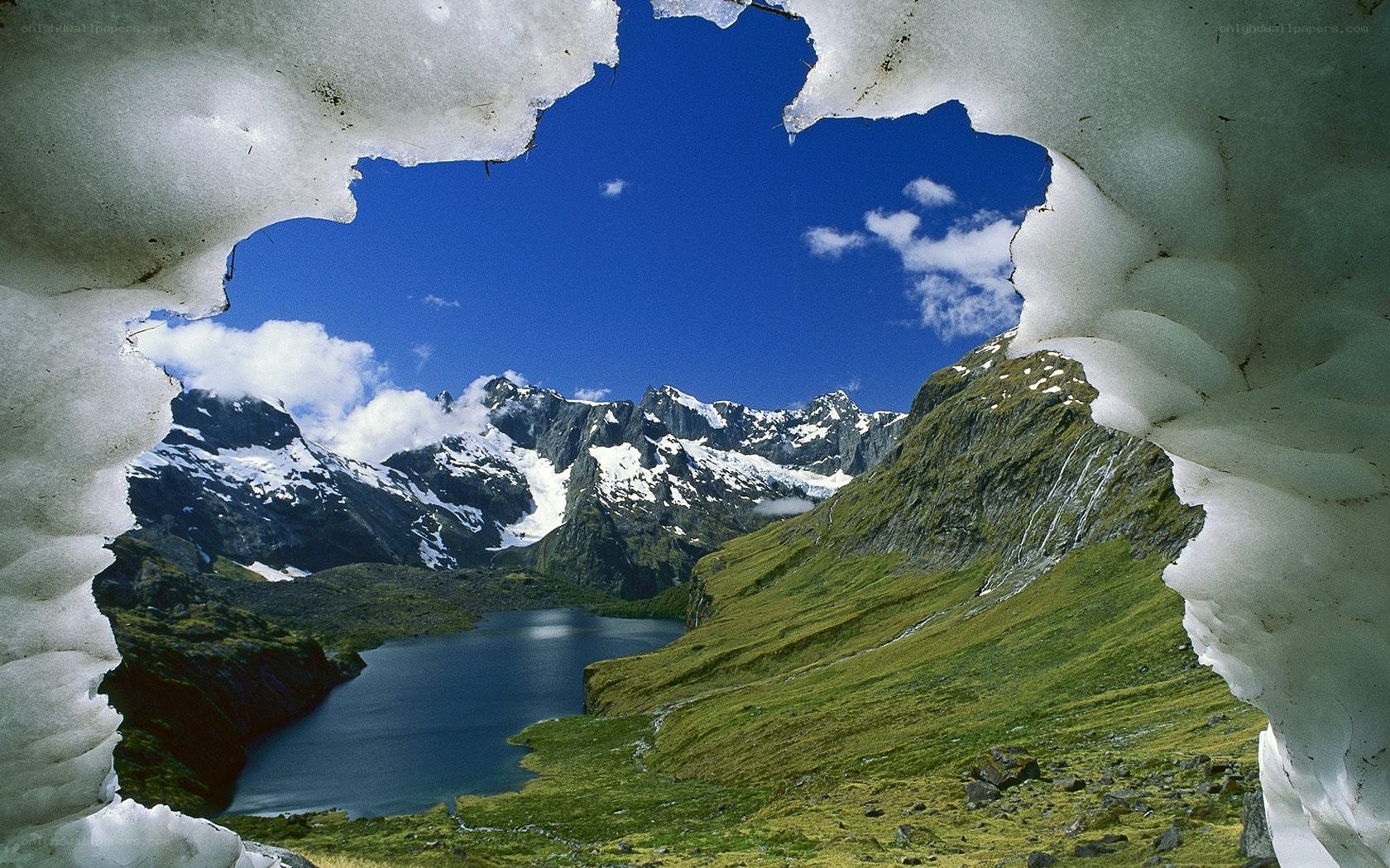 Mountain lake through snow tunnel