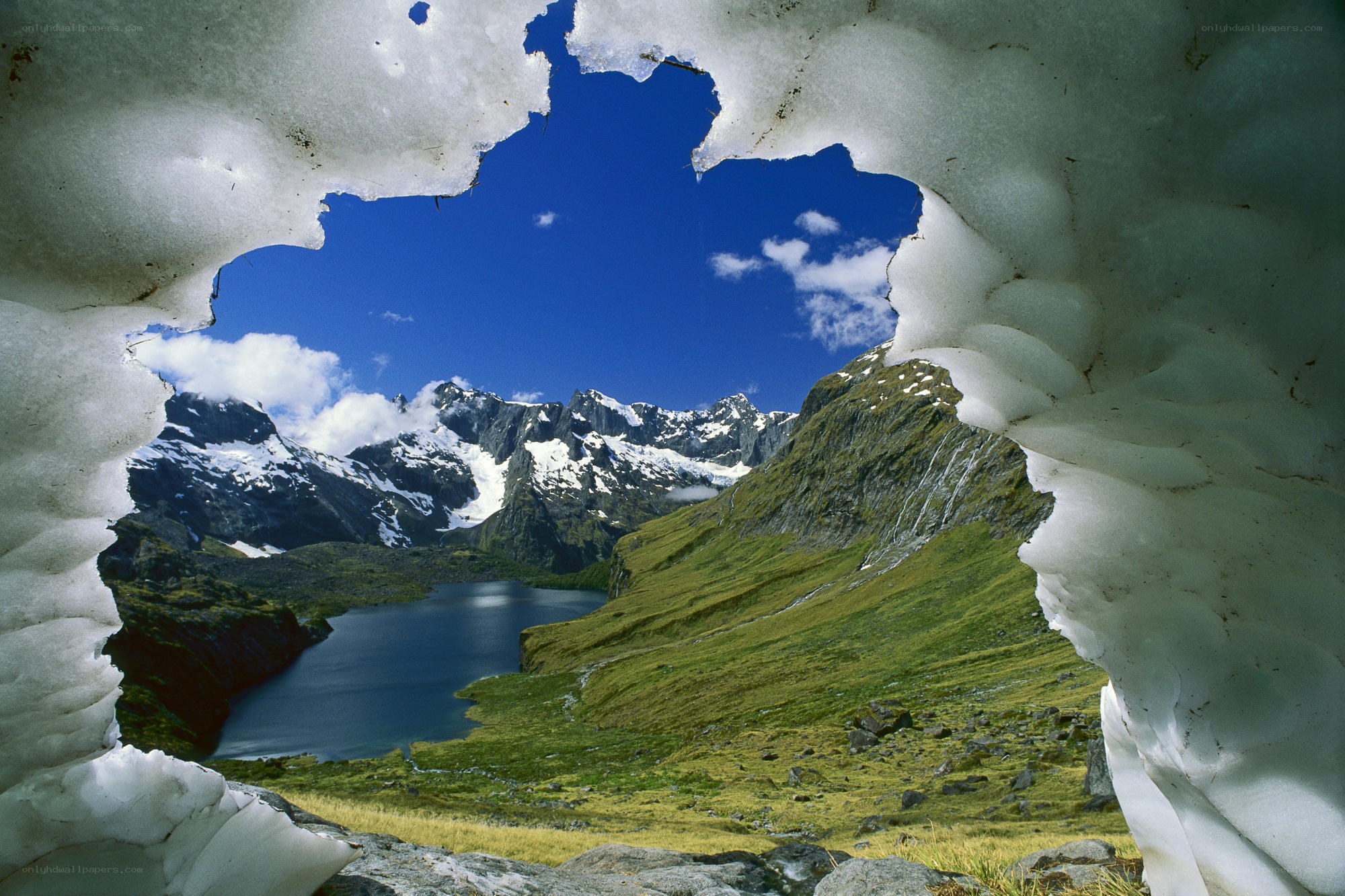 Mountain lake through snow tunnel
