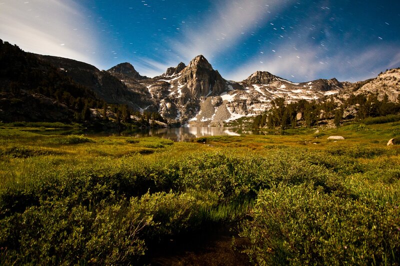 Mountain lake under star trails