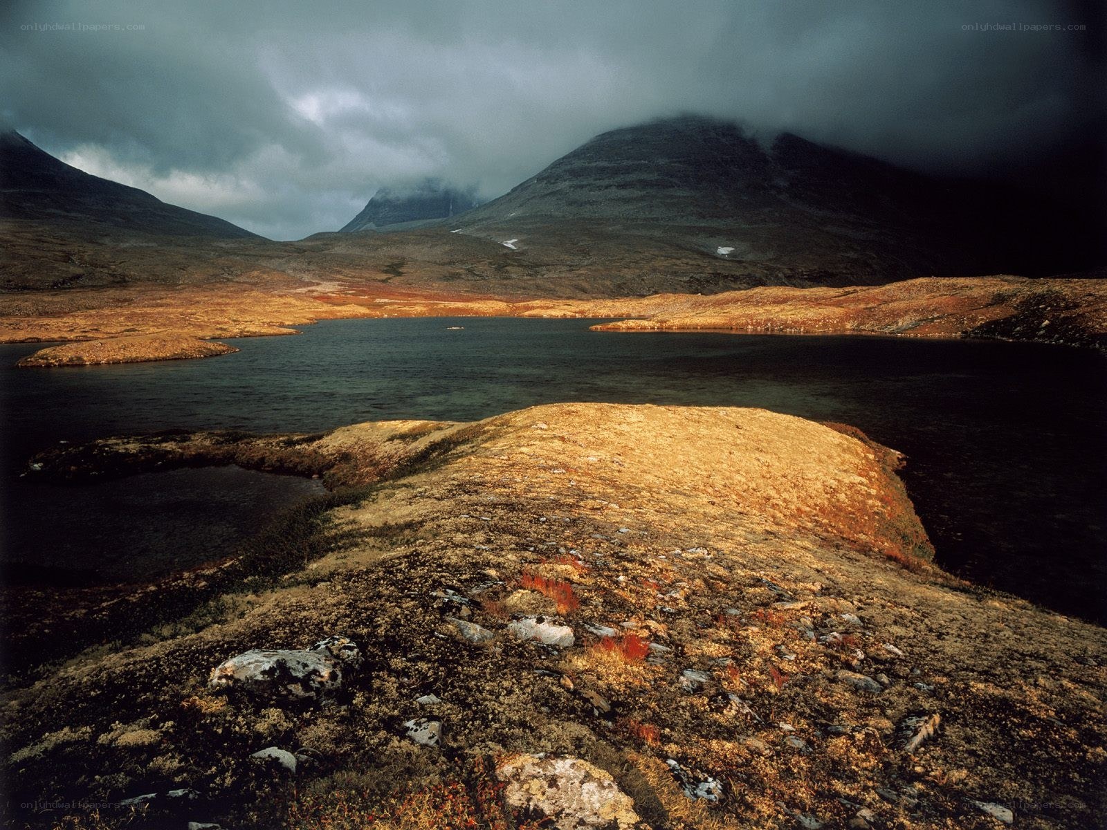 Mountain lake under stormy sky