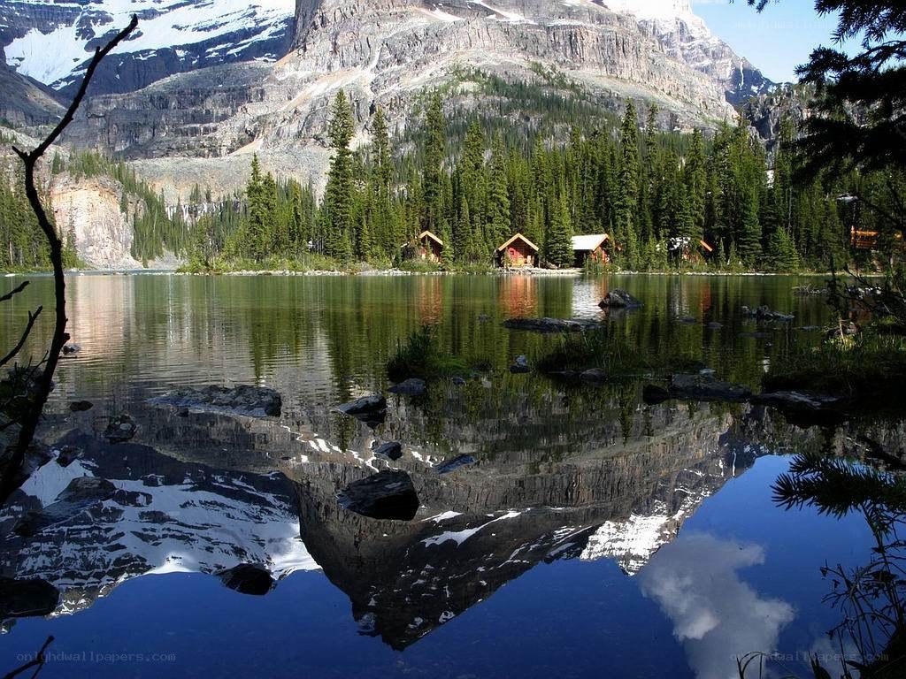 Mountain lake with cabin reflection