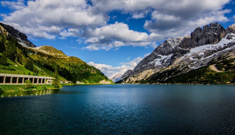 Mountain lake with dam and peaks