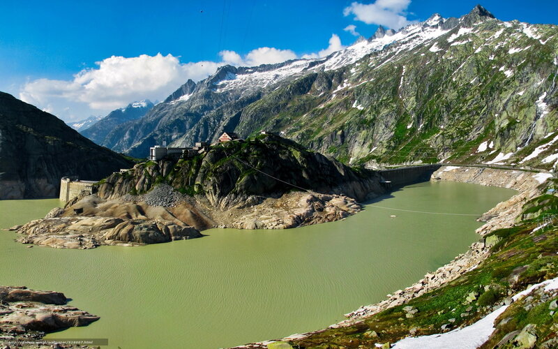 Mountain lake with dam and peaks