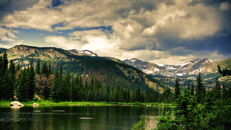Mountain lake with forest and snow-capped peaks