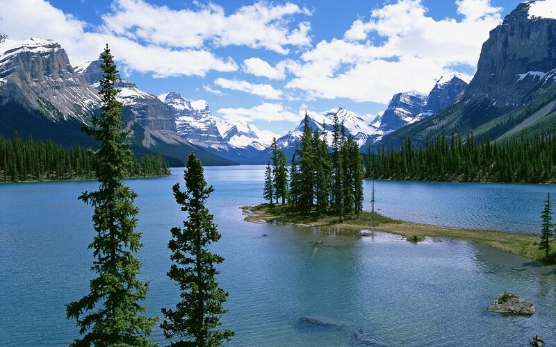 Mountain lake with forest and snow-capped peaks
