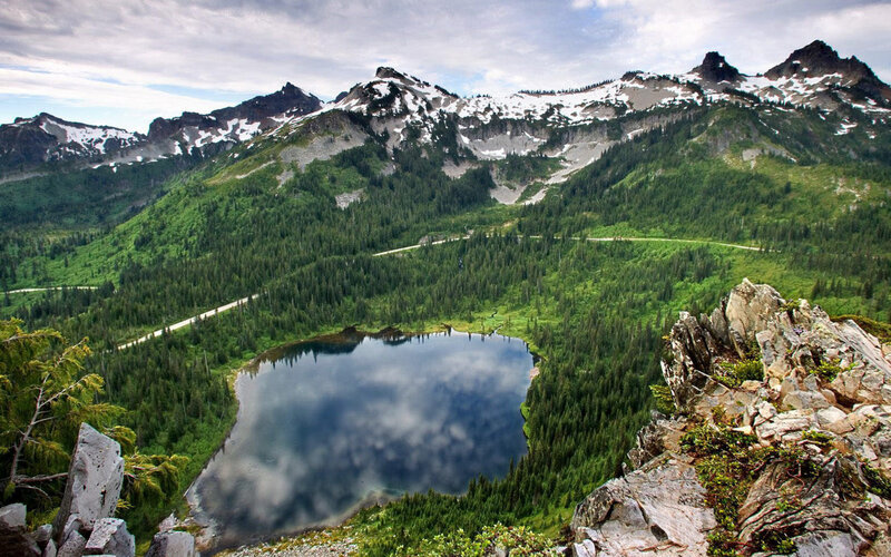 Mountain lake with forest and snow-capped peaks