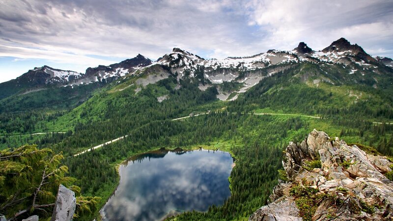 Mountain lake with forest and snow-capped peaks