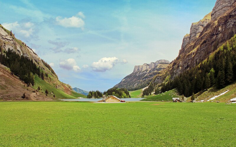 Mountain lake with green fields
