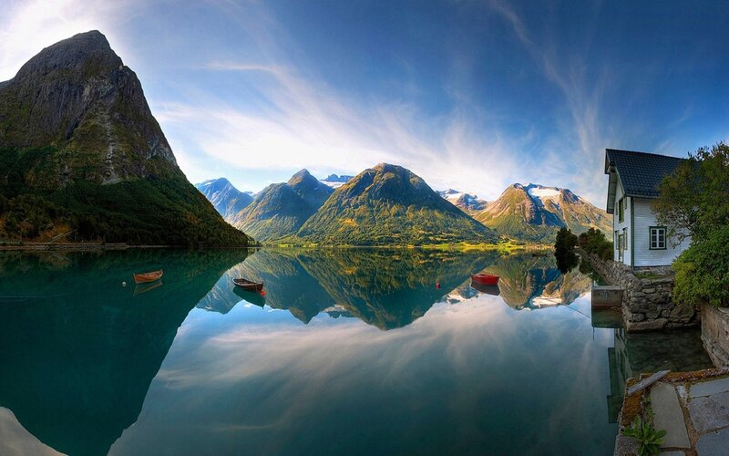 Mountain lake with house and boats