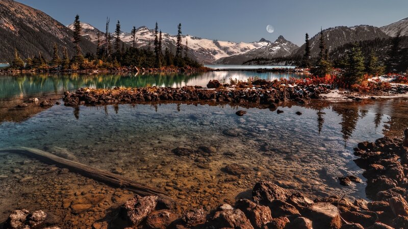 Mountain lake with moon and snow