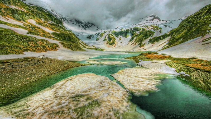 Mountain lake with snow and greenery