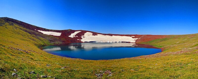 Mountain lake with snow patches