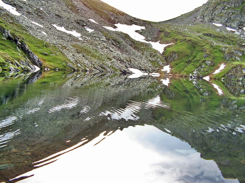 Mountain lake with snow patches