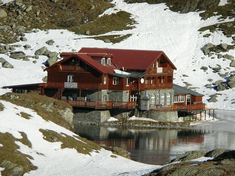 Mountain lodge by a frozen lake