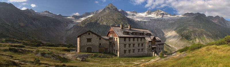 Mountain lodge with alpine peaks