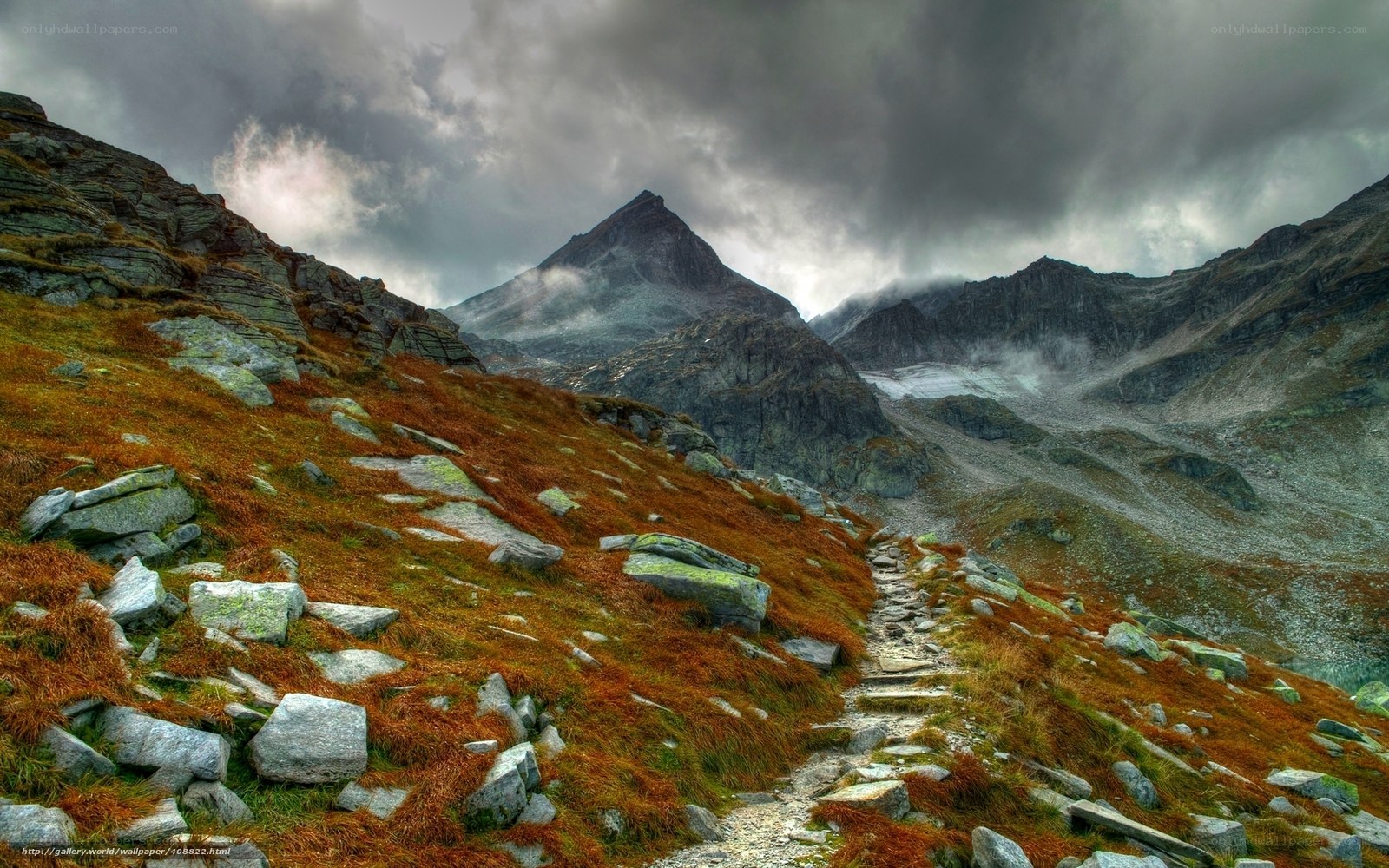 Mountain path under stormy sky