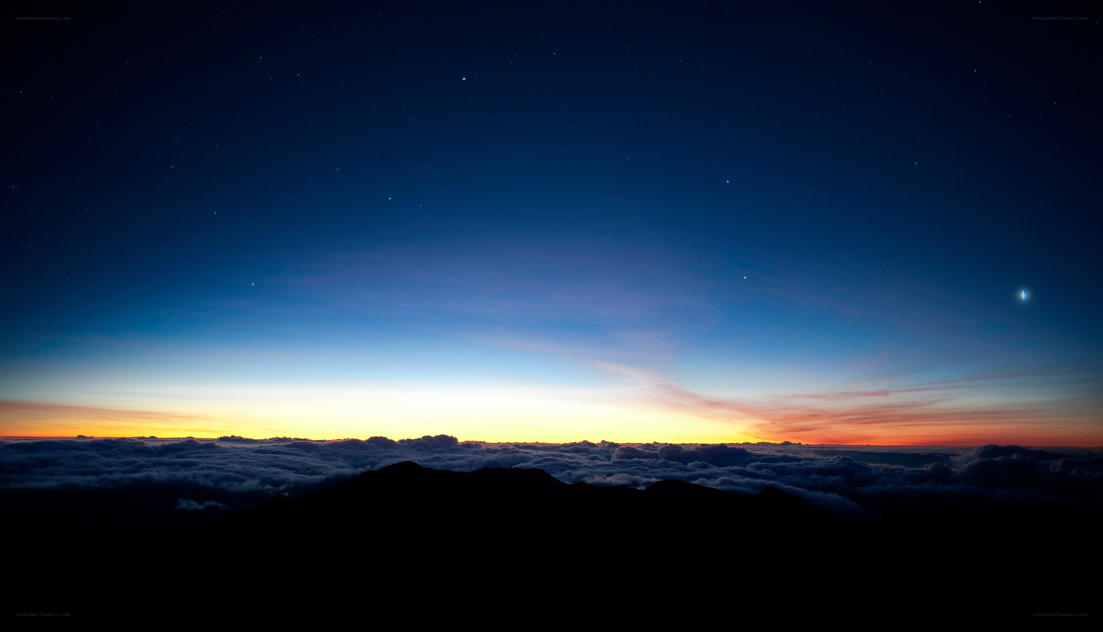 Mountain peak above clouds at dawn