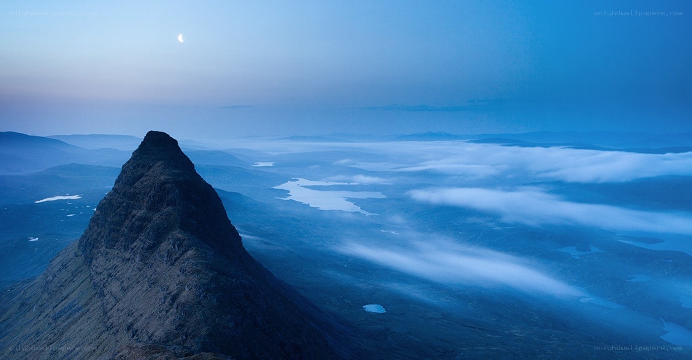 Mountain peak above clouds at dusk