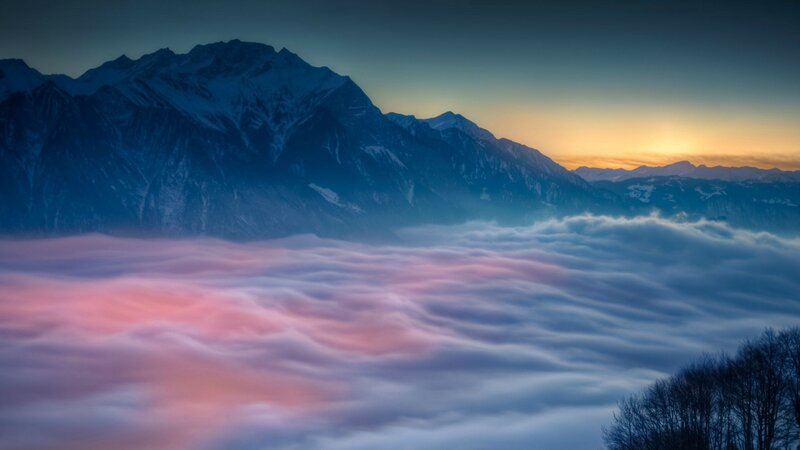 mountain peak above clouds at sunrise