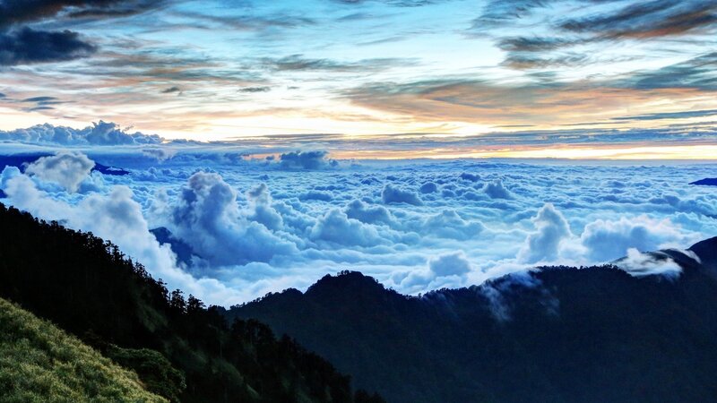 mountain peak above clouds at sunrise