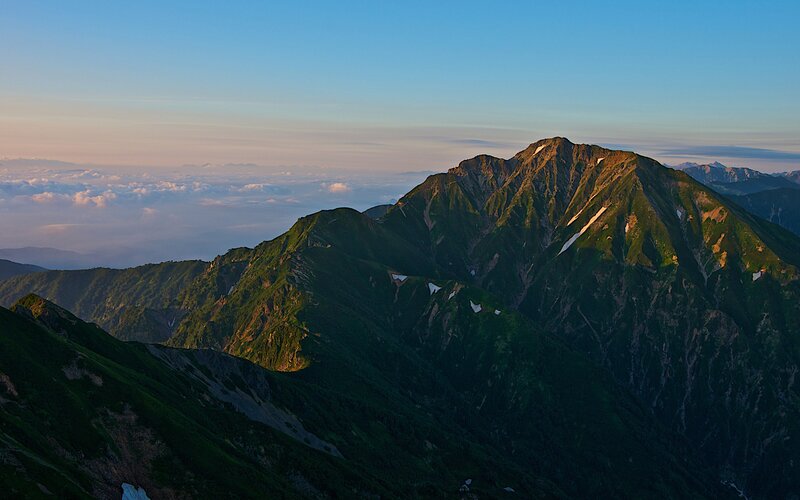 Mountain peak above clouds at sunrise