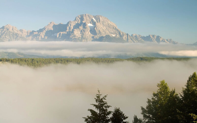 Mountain peak above foggy forest