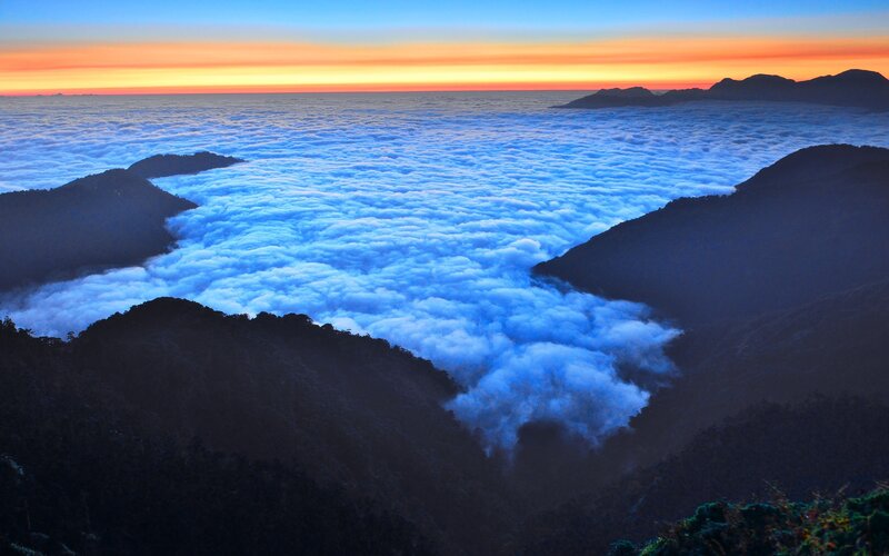 Mountain peak above sea of clouds